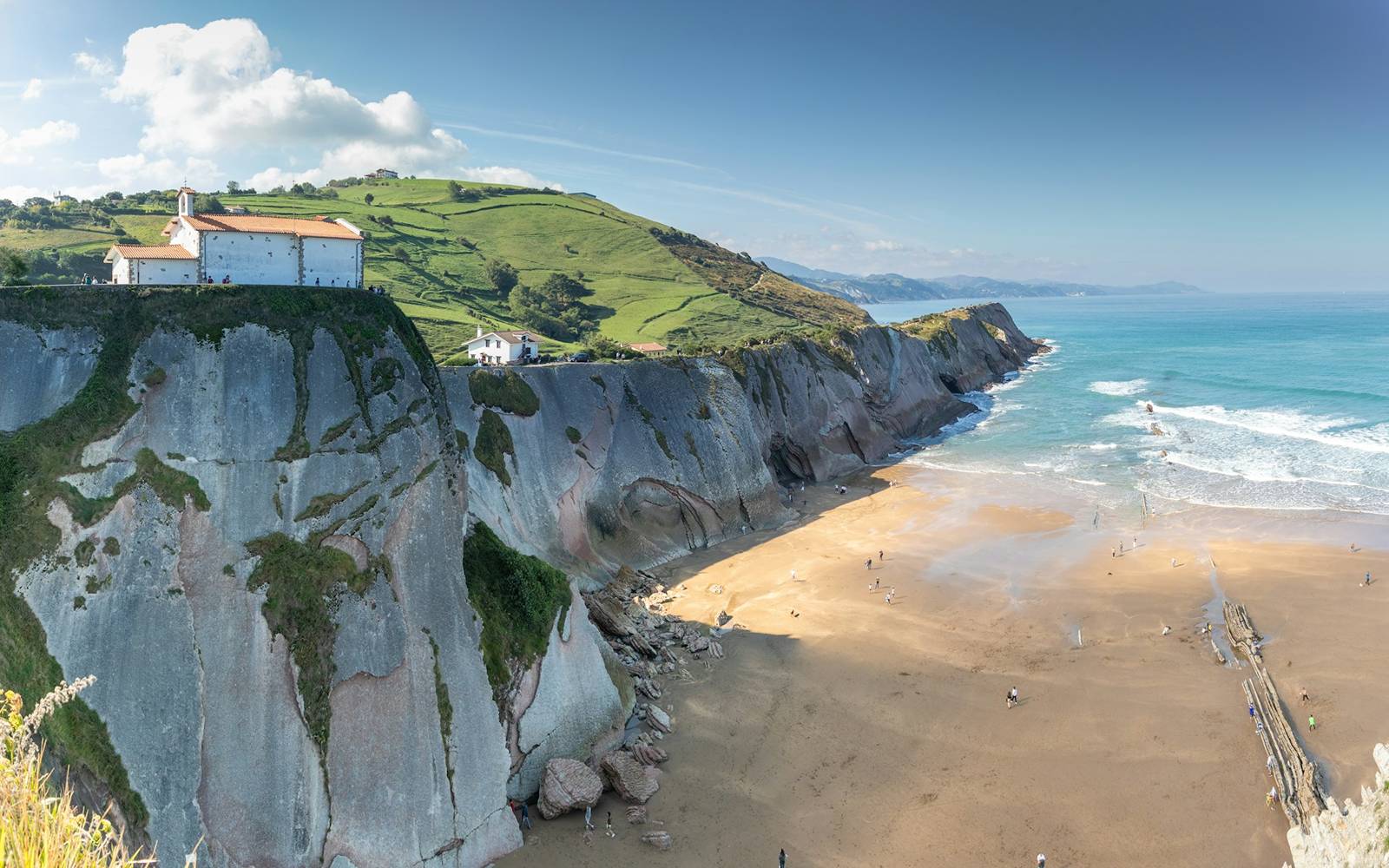 The Zumaia flysch cliffs on the Basque coast - dramatic striped rock formations sixty million years in the making, above a wide sandy Atlantic beach